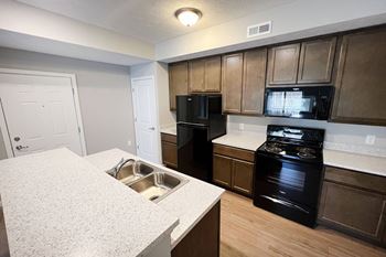 A kitchen with black appliances and white counter tops